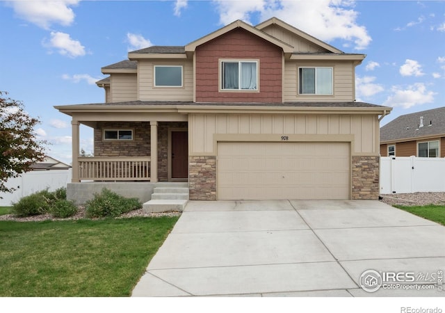 978 Mouflon Dr, Severance, CO 80550 - view of front of property featuring covered porch, stone siding, a garage, concrete driveway, and roof with shingles