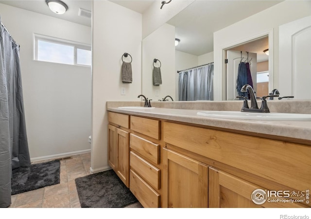 978 Mouflon Dr, Severance, CO 80550 - bathroom featuring double vanity, toilet, curtained shower, and baseboards