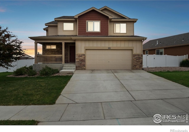 978 Mouflon Dr, Severance, CO 80550 - view of front facade with a porch, stone siding, an attached garage, driveway, and board and batten siding