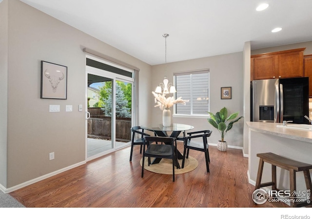 6492 Richland Ave, Timnath, CO 80547 - dining area featuring baseboards, dark wood-style floors, recessed lighting, and a chandelier