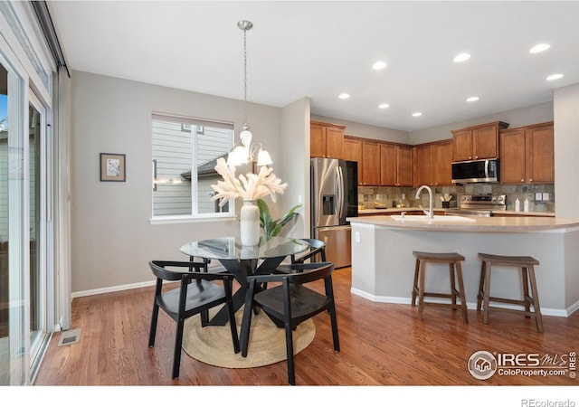 6492 Richland Ave, Timnath, CO 80547 - dining space featuring light wood-style floors, recessed lighting, a chandelier, and baseboards