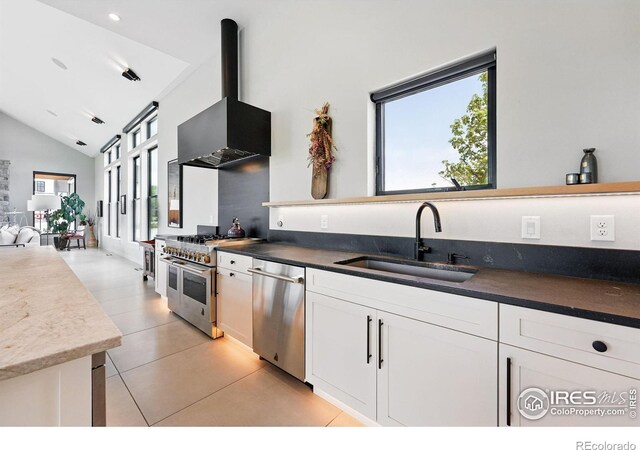 1563 Spring Creek Xing, Lafayette, CO 80026 - kitchen featuring a sink, appliances with stainless steel finishes, wall chimney range hood, white cabinetry, and lofted ceiling