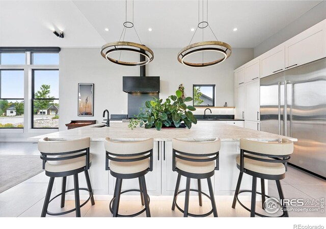 1563 Spring Creek Xing, Lafayette, CO 80026 - kitchen featuring stainless steel built in refrigerator, white cabinets, a sink, a large island, and recessed lighting