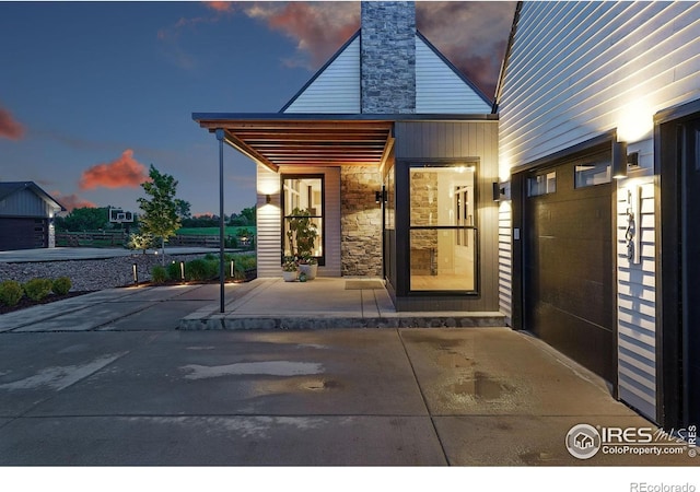 1563 Spring Creek Xing, Lafayette, CO 80026 - exterior entry at dusk featuring stone siding and a chimney
