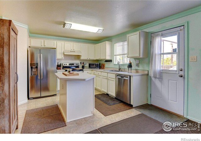 5241 E 128th Way, Thornton, CO 80241 - kitchen featuring stainless steel appliances, under cabinet range hood, a sink, light countertops, and a kitchen island