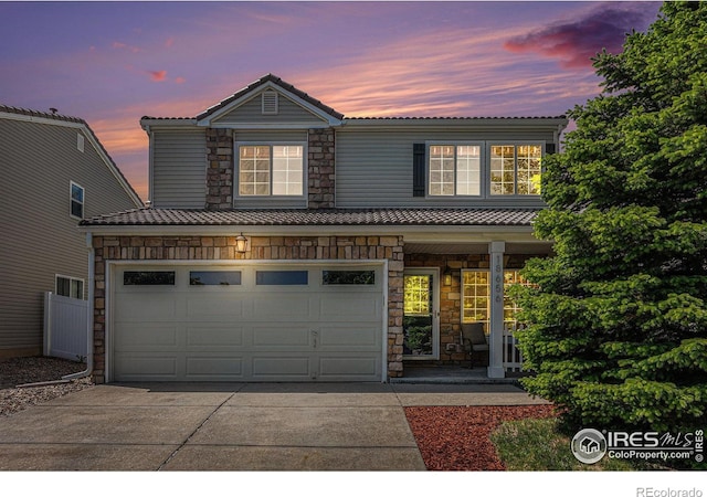 18656 Kelly Pl, Denver, CO 80249 - traditional-style house with driveway, stone siding, an attached garage, and a porch