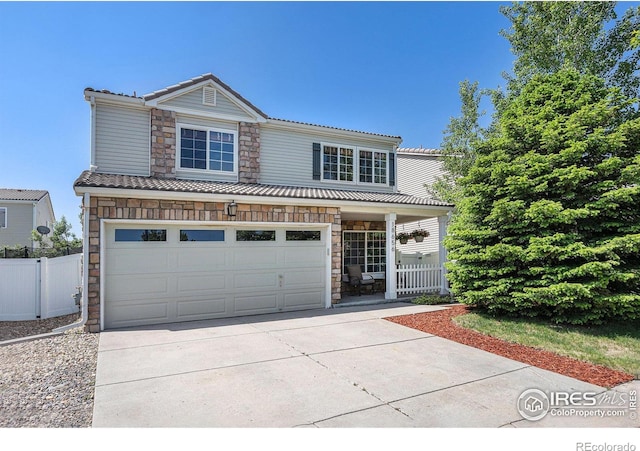 18656 Kelly Pl, Denver, CO 80249 - traditional-style home featuring stone siding, driveway, a tiled roof, covered porch, and an attached garage