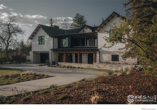 2100 Kohler Dr, Boulder, CO 80305 - view of front of property featuring stone siding, a balcony, an attached garage, and a chimney