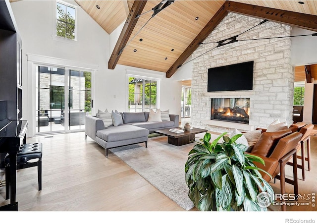 2100 Kohler Dr, Boulder, CO 80305 - living room with wooden ceiling with exposed beams, wood finished floors, high vaulted ceiling, a stone fireplace, and plenty of natural light