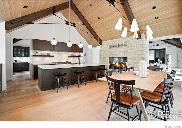 2100 Kohler Dr, Boulder, CO 80305 - dining room featuring light wood-style flooring, wood ceiling with exposed beams, a stone fireplace, and high vaulted ceiling