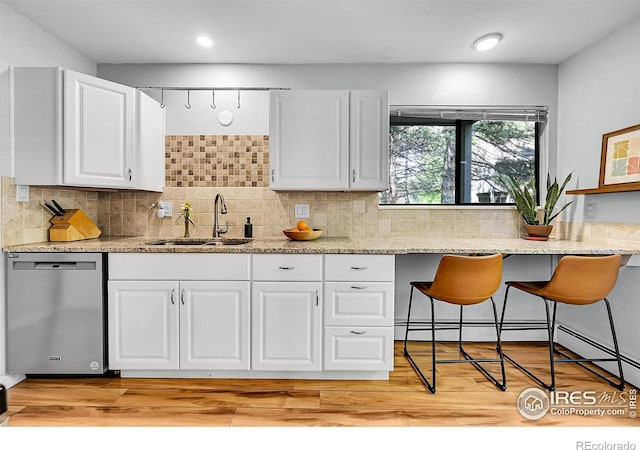 705 E Drake Rd Unit 37, Fort Collins, CO 80525 - kitchen featuring stainless steel dishwasher, a sink, white cabinets, tasteful backsplash, and recessed lighting