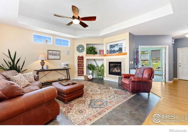633 Deerwood Dr, Longmont, CO 80504 - living area with a raised ceiling, a ceiling fan, healthy amount of natural light, and a fireplace