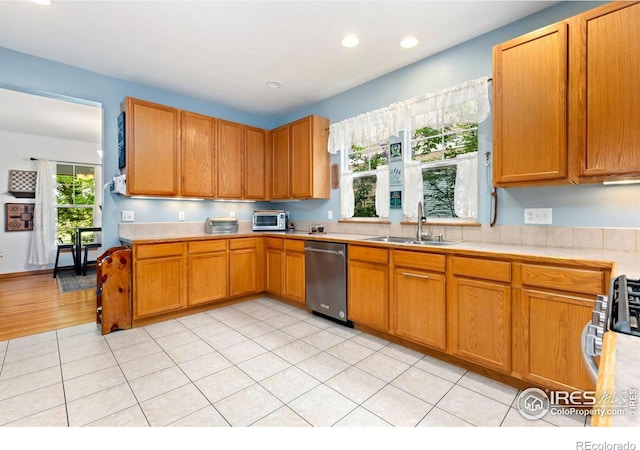 633 Deerwood Dr, Longmont, CO 80504 - kitchen with stainless steel appliances, light countertops, recessed lighting, light tile patterned flooring, and brown cabinetry