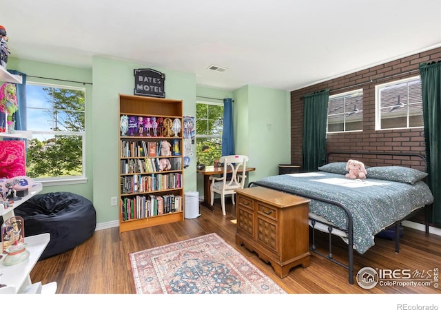 633 Deerwood Dr, Longmont, CO 80504 - bedroom with wood finished floors and brick wall