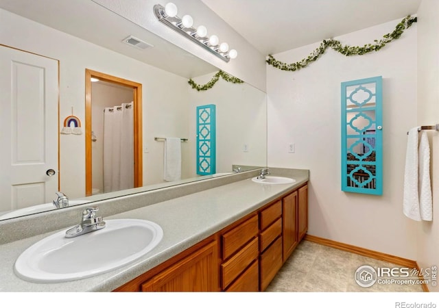 633 Deerwood Dr, Longmont, CO 80504 - bathroom featuring double vanity and baseboards