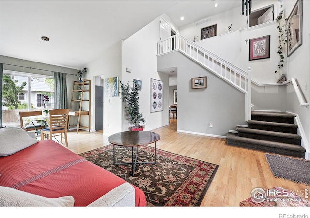 823 Timothy Dr, Longmont, CO 80503 - living room featuring wood finished floors, stairs, recessed lighting, a towering ceiling, and baseboards
