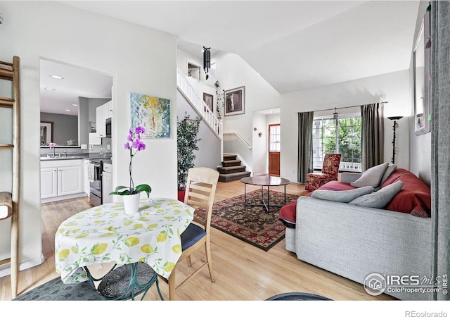 823 Timothy Dr, Longmont, CO 80503 - living room with light wood-style flooring, stairs, and vaulted ceiling