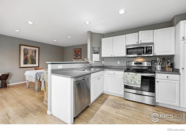 823 Timothy Dr, Longmont, CO 80503 - kitchen with appliances with stainless steel finishes, a sink, light wood-type flooring, a peninsula, and white cabinetry