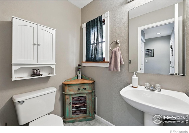 823 Timothy Dr, Longmont, CO 80503 - half bathroom featuring toilet, a sink, and tile patterned floors