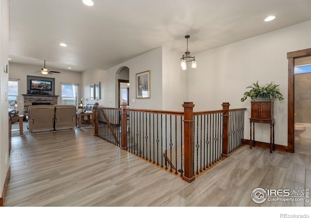 5532 Maidenhead Dr, Windsor, CO 80550 - hall featuring wood finished floors, recessed lighting, arched walkways, and a chandelier