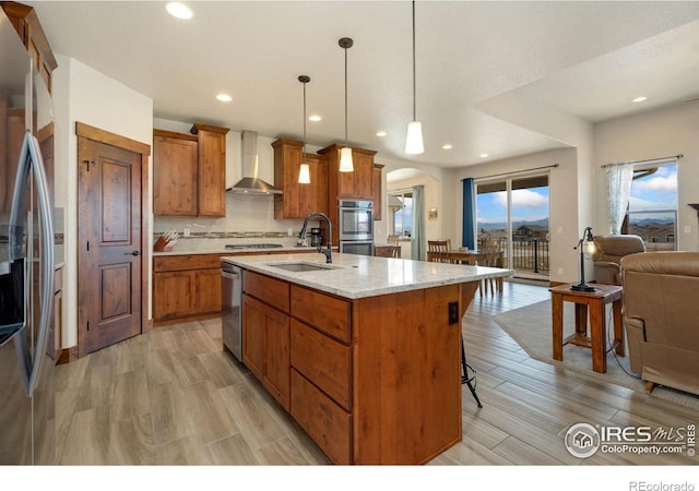 5532 Maidenhead Dr, Windsor, CO 80550 - kitchen featuring wall chimney exhaust hood, a sink, stainless steel appliances, arched walkways, and brown cabinetry