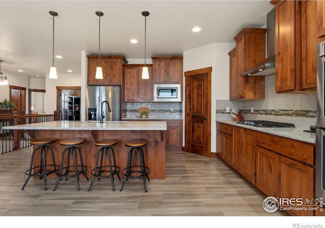 5532 Maidenhead Dr, Windsor, CO 80550 - kitchen featuring appliances with stainless steel finishes, wall chimney exhaust hood, brown cabinets, tasteful backsplash, and a sink