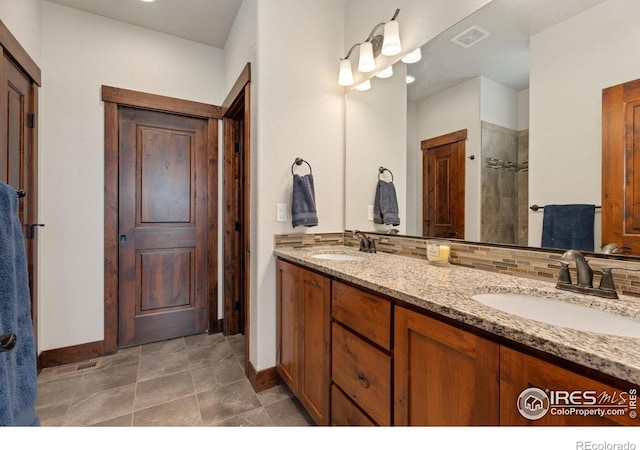 5532 Maidenhead Dr, Windsor, CO 80550 - full bath with baseboards, double vanity, a tile shower, and tasteful backsplash