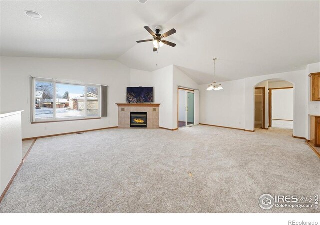 2615 Anemonie Dr, Loveland, CO 80537 - unfurnished living room with vaulted ceiling, a tile fireplace, light carpet, arched walkways, and a ceiling fan