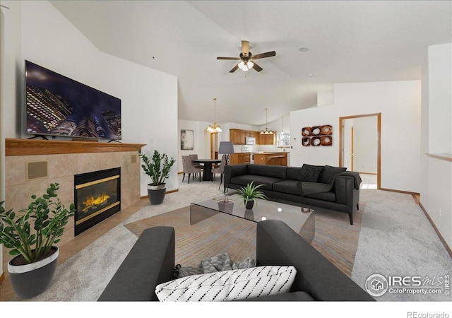 2615 Anemonie Dr, Loveland, CO 80537 - carpeted living room featuring vaulted ceiling, a ceiling fan, a tile fireplace, and baseboards