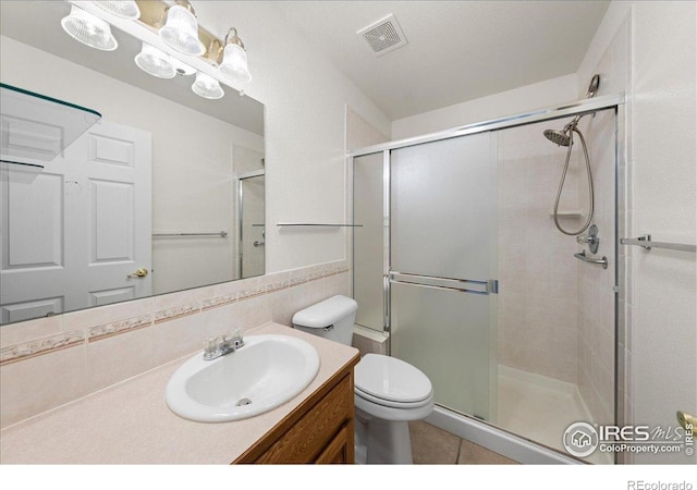 2615 Anemonie Dr, Loveland, CO 80537 - full bathroom with vanity, a stall shower, toilet, tile patterned floors, and tasteful backsplash