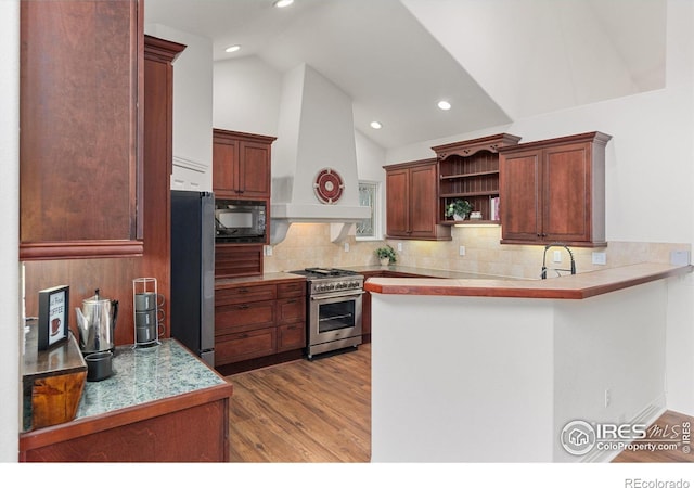 2549 Cowley Dr, Lafayette, CO 80026 - kitchen with appliances with stainless steel finishes, custom exhaust hood, a peninsula, lofted ceiling, and open shelves