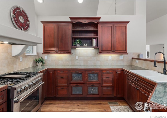2549 Cowley Dr, Lafayette, CO 80026 - kitchen with stainless steel range, dark brown cabinets, a sink, light wood-style floors, and tasteful backsplash