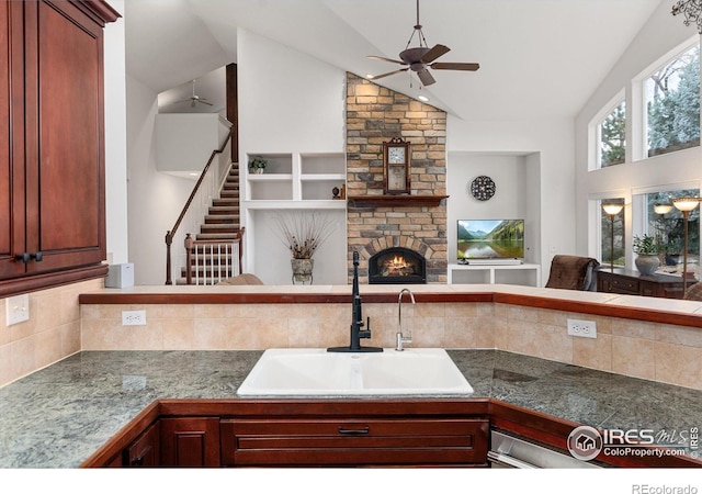2549 Cowley Dr, Lafayette, CO 80026 - kitchen featuring a sink, ceiling fan, open floor plan, tasteful backsplash, and a stone fireplace