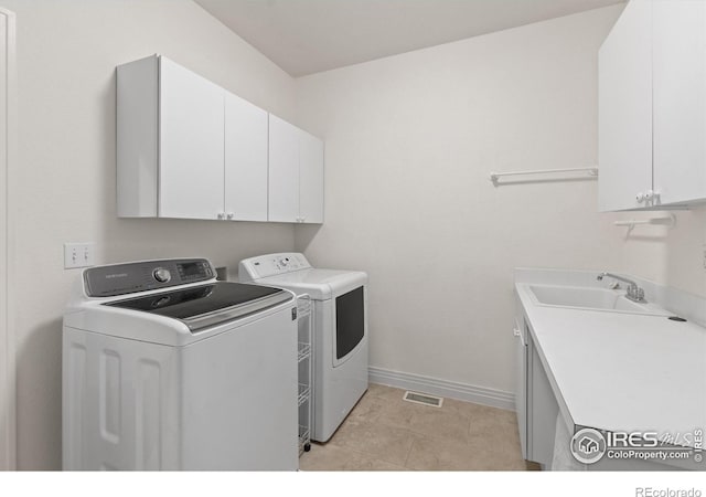 2549 Cowley Dr, Lafayette, CO 80026 - washroom with cabinet space, washer and clothes dryer, baseboards, and light tile patterned floors
