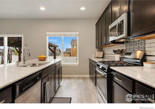 426 Gannet Peak Dr, Windsor, CO 80550 - kitchen with stainless steel appliances, a sink, tasteful backsplash, light stone counters, and recessed lighting