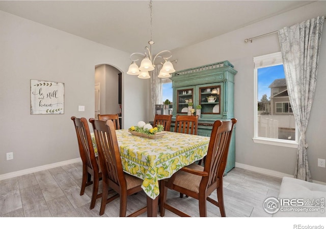 426 Gannet Peak Dr, Windsor, CO 80550 - dining area with arched walkways, a chandelier, light wood finished floors, and healthy amount of natural light