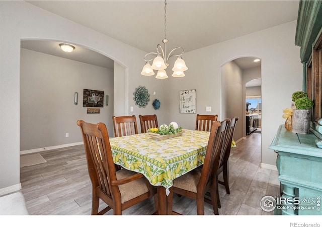 426 Gannet Peak Dr, Windsor, CO 80550 - dining area with arched walkways, light wood-style floors, baseboards, and a chandelier