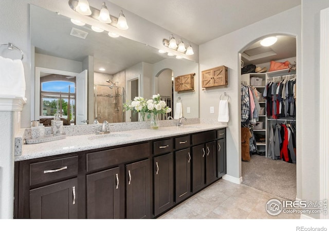 426 Gannet Peak Dr, Windsor, CO 80550 - bathroom featuring double vanity, a stall shower, a spacious closet, and tile patterned flooring