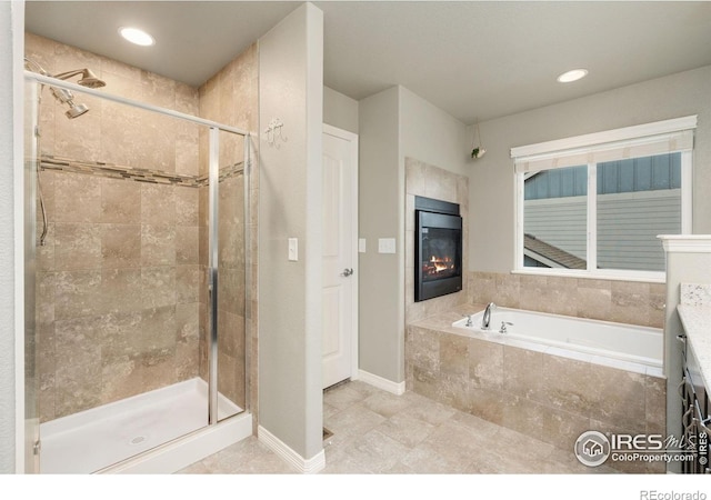 426 Gannet Peak Dr, Windsor, CO 80550 - bathroom with a shower stall, a fireplace, a garden tub, baseboards, and tile patterned flooring