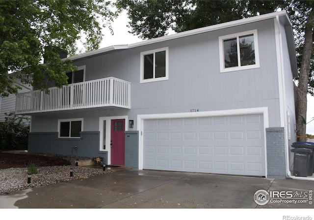 1714 Zeus Dr, Lafayette, CO 80026 - view of front of home featuring brick siding, a balcony, an attached garage, and concrete driveway