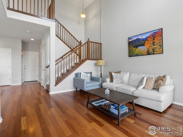 4795 Raven Run, Broomfield, CO 80023 - living area with stairway, wood finished floors, a towering ceiling, and baseboards