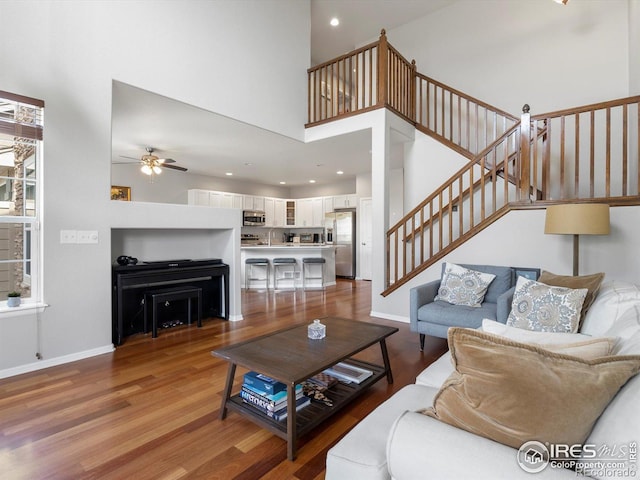 4795 Raven Run, Broomfield, CO 80023 - living area with ceiling fan, stairway, wood finished floors, baseboards, and a high ceiling