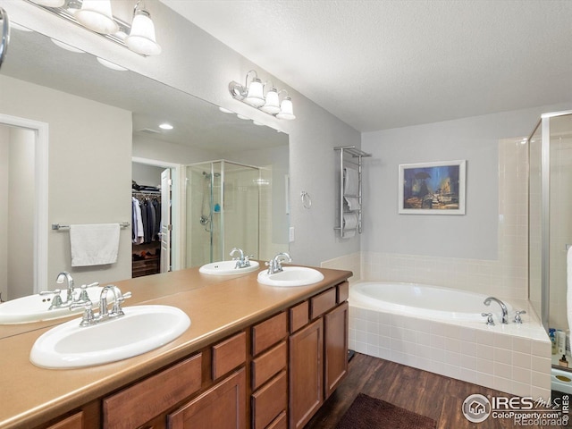4795 Raven Run, Broomfield, CO 80023 - bathroom featuring a shower stall, a bath, a spacious closet, double vanity, and wood finished floors