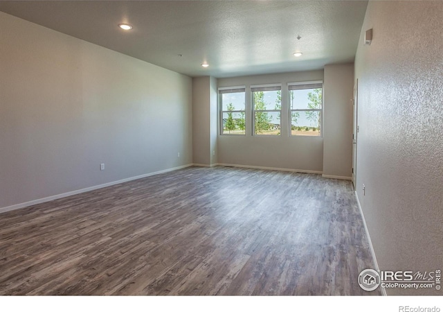 1811 Bounty Dr Unit 4, Windsor, CO 80550 - spare room with wood finished floors, recessed lighting, baseboards, a textured wall, and a textured ceiling