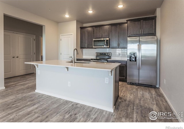 1811 Bounty Dr Unit 4, Windsor, CO 80550 - kitchen featuring stainless steel appliances, a sink, light wood-type flooring, a center island with sink, and recessed lighting
