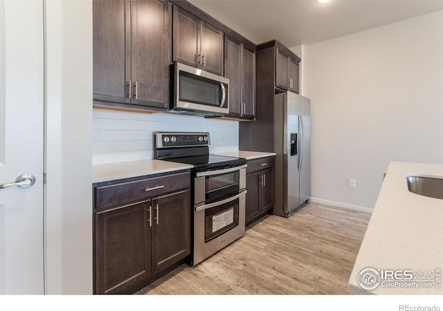 1811 Bounty Dr Unit 4, Windsor, CO 80550 - kitchen with stainless steel appliances, light countertops, dark brown cabinetry, tasteful backsplash, and light wood-type flooring