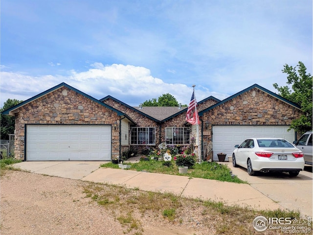 112-114 8th St, Gilcrest, CO 80623 - view of front of property with driveway, a garage, and stone siding
