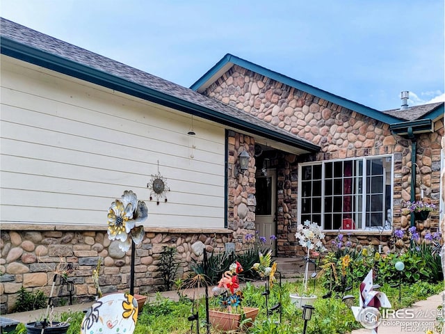112-114 8th St, Gilcrest, CO 80623 - view of exterior entry featuring stone siding and a shingled roof