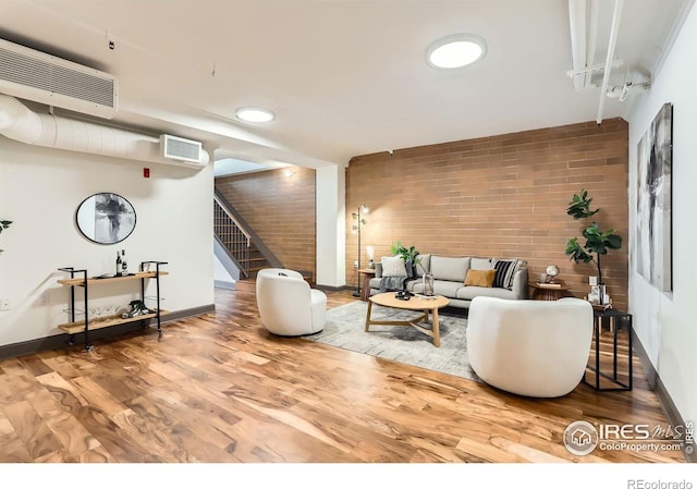 2245 Blake St Unit D, Denver, CO 80205 - living area with brick wall, stairs, and wood finished floors