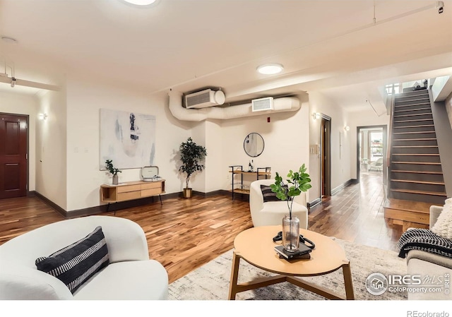 2245 Blake St Unit D, Denver, CO 80205 - living room featuring wood finished floors, stairway, and a wall mounted air conditioner